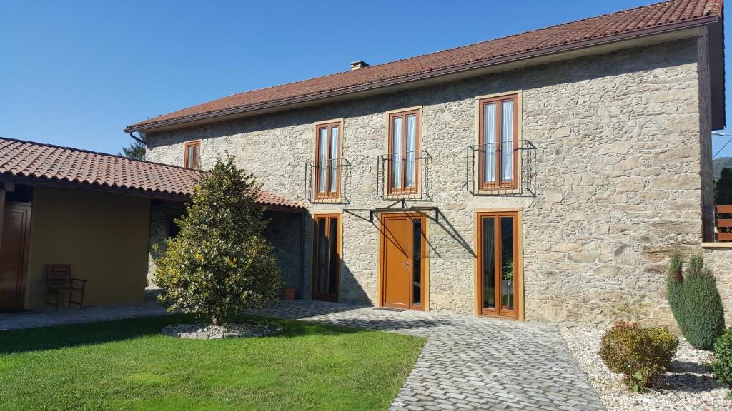 une ancienne maison en pierre avec un chemin en face de celle-ci dans l'établissement Casa da Paioca, à Paleo