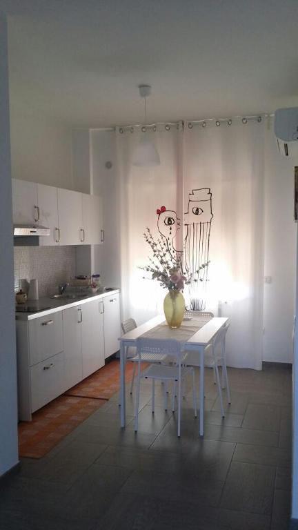 a white kitchen with a table with a vase on it at B&B Stefyld in Paola