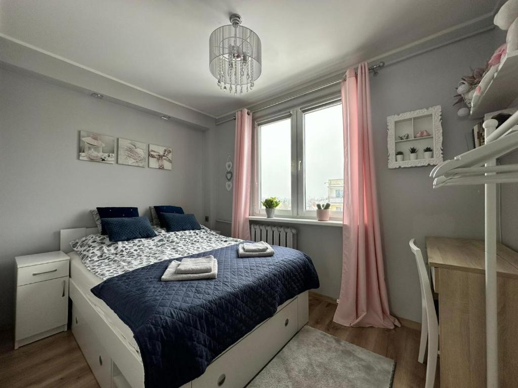 a bedroom with a bed with blue sheets and a window at Mazury Witaj in Ostróda