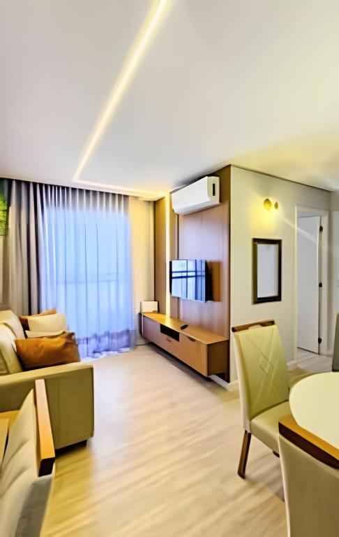 a living room with a couch and a television at Apto 2/4 com Wi-Fi, TV, piscina e garagem | 1402 in Campinas