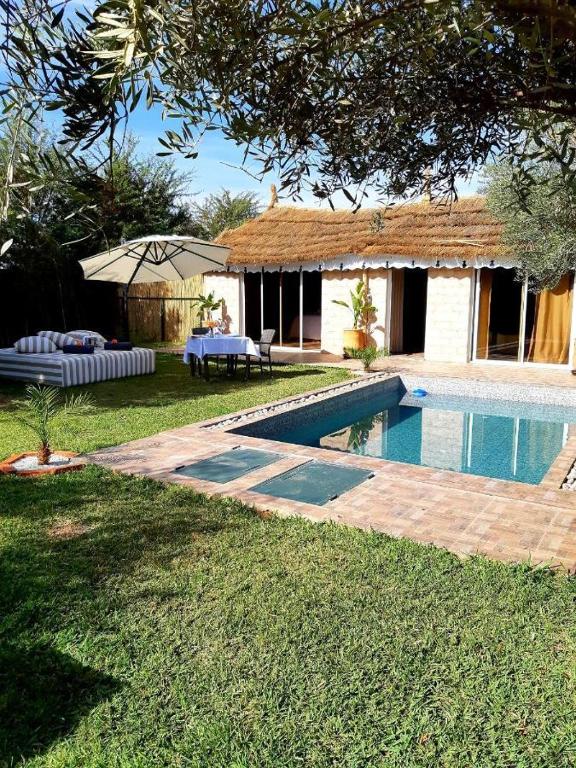 a house with a swimming pool in a yard at Dar Tissila in Marrakesh