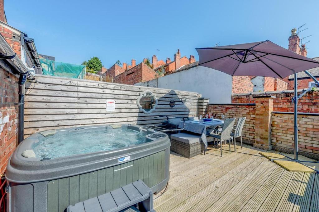 a hot tub on a deck with an umbrella at 3 Bed in Lincoln oc-a30207 in Lincoln