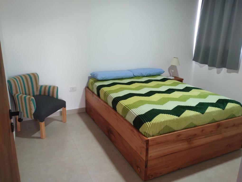 a bedroom with a bed and a chair at Departamento 2 ambientes complejo Marlu in Federación
