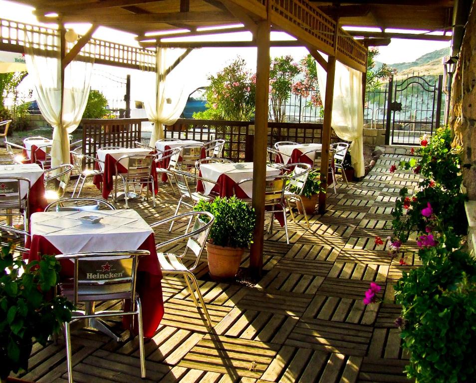 restauracja ze stołami i krzesłami na patio w obiekcie Hotel Miramare w mieście Bosa Marina