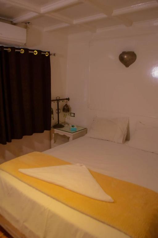 a bedroom with a bed and a black curtain at Water Lily in Luxor