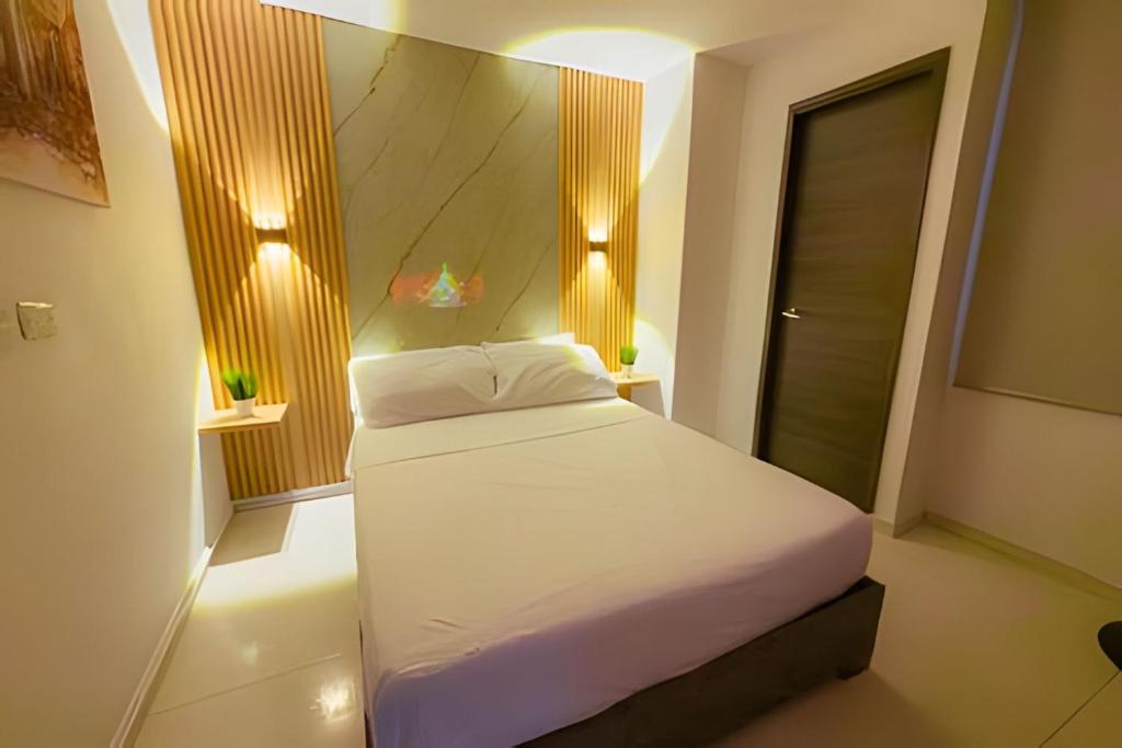 a bedroom with a white bed with lights on it at hermoso apartasuite con la mejor ubicación in Cartago