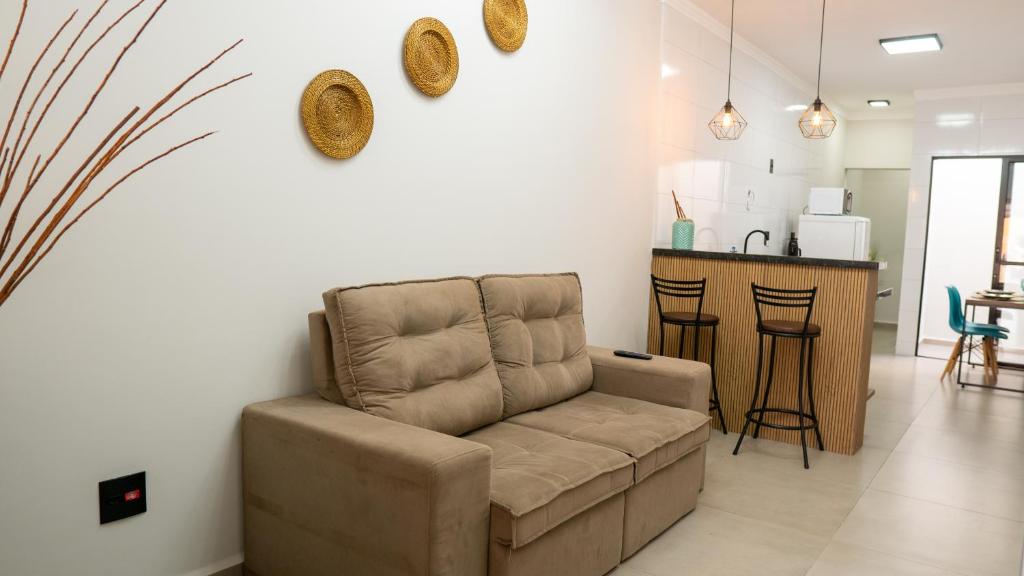a living room with a couch and a kitchen at Jahu Center Casas Un 3 in Jaú