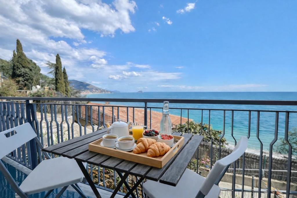 a tray of food sitting on a table on a balcony at Vista Mare, Netflix & AC - Smeraldo Apartment in Laigueglia