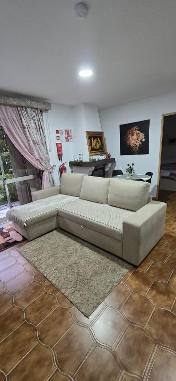 a living room with a white couch and a rug at Moradia Belo horizonte in Alfena
