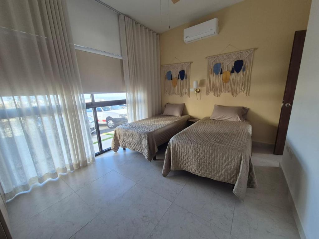 a bedroom with two beds and a window at Turquesa depa in Cabo San Lucas