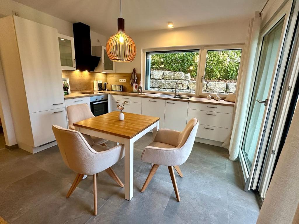 a kitchen with a table and chairs and a sink at Autumn Apartment in Gerbrunn