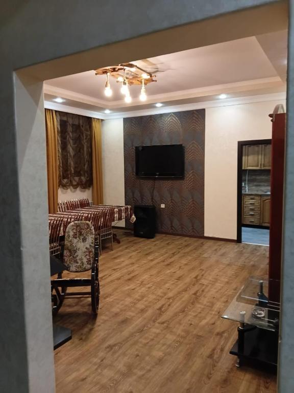 a living room with a table and a flat screen tv at Villa Gast Haus in Tsaghkadzor