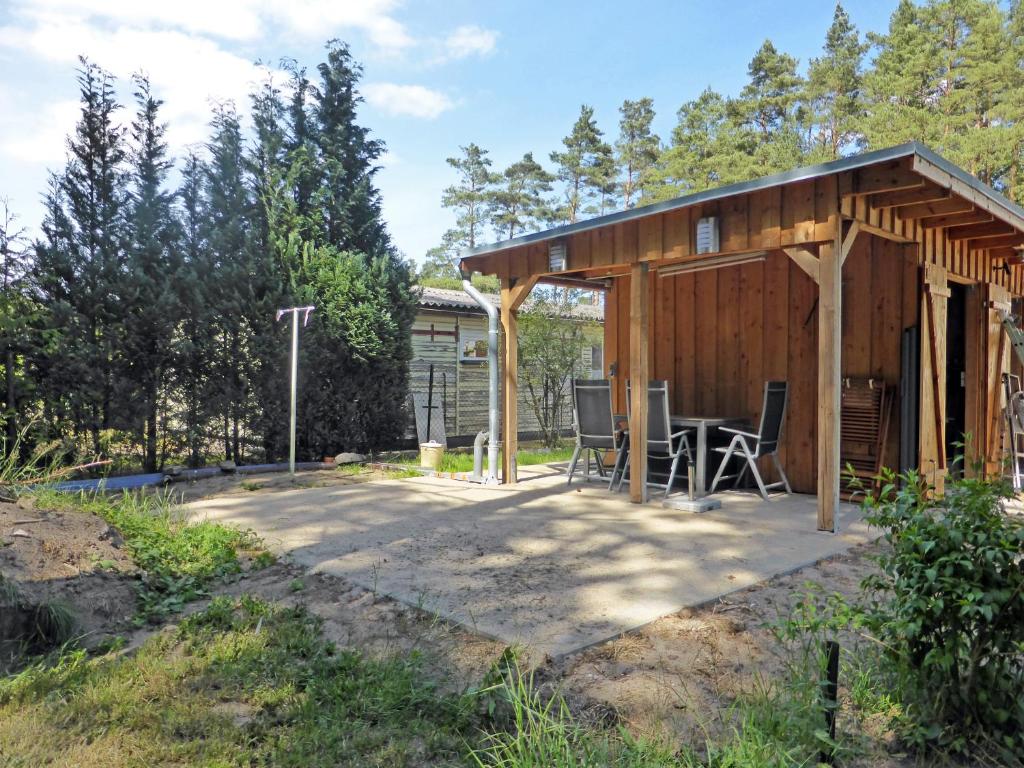 eine Hütte mit einem Tisch und Stühlen im Hof in der Unterkunft Ferienwohnungen am Waldessaum in Bodstedt