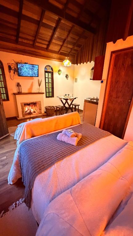 a bedroom with two beds and a fireplace at Chalés Lua de Mel in Monte Verde