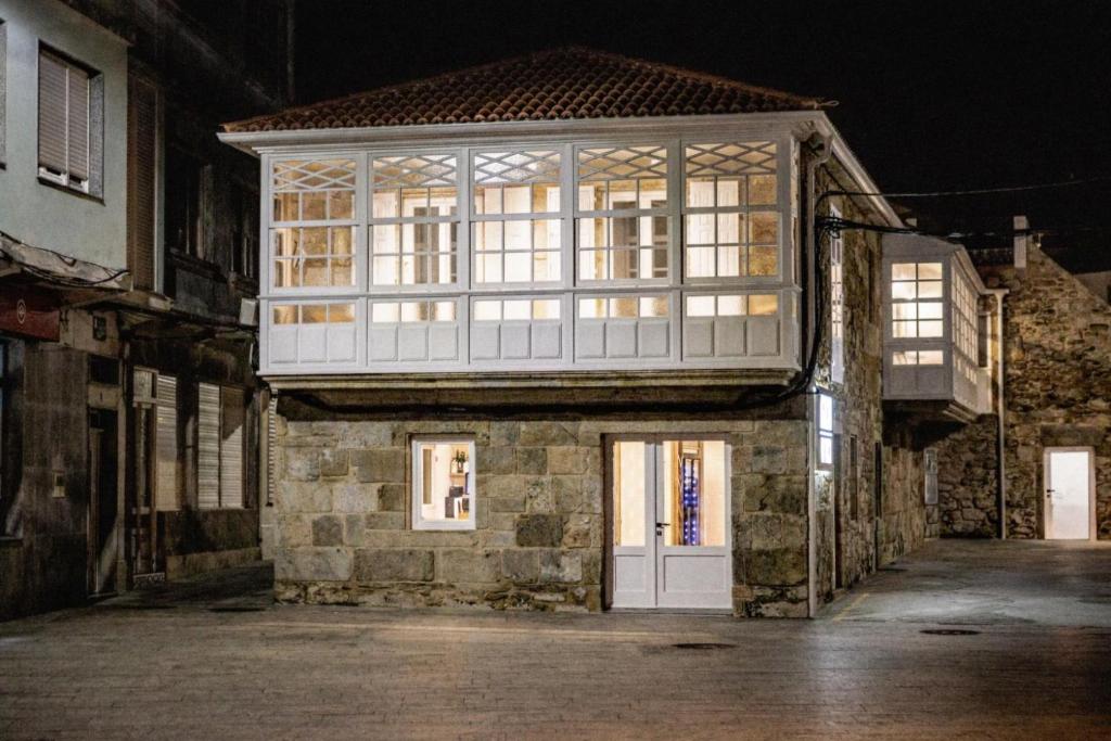 a building with a large window on top of it at Do Bico Rooms in Camariñas