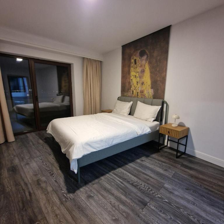 a bedroom with a bed with a painting on the wall at Viilor Panoramic in Baia Mare