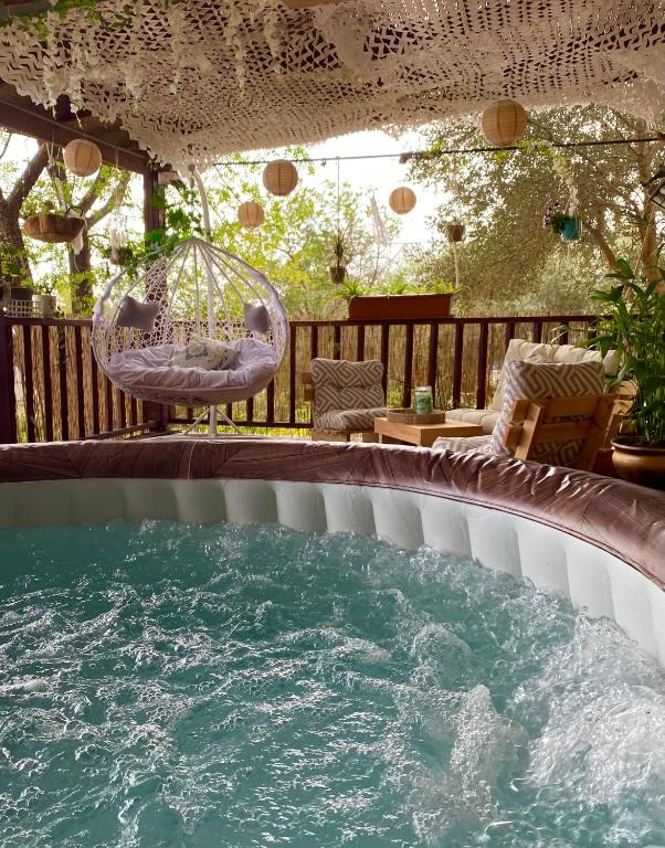 a swimming pool with a chair and a swing at Boho B&B in Amnon