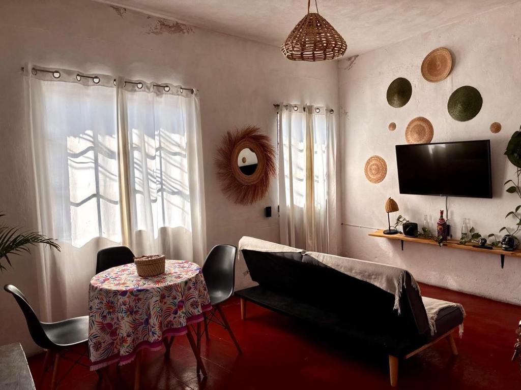 a living room with a table and a tv at Casa Roma in Taxco de Alarcón