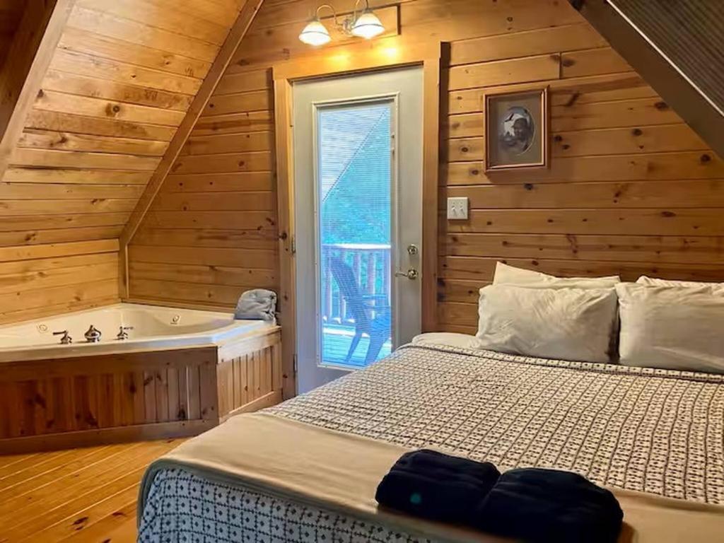 a bedroom with a bed and a bath tub at Mountain Memories - RRG in Rogers