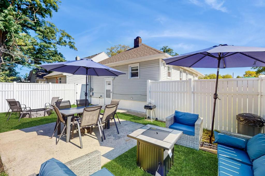 a patio with a table and chairs and umbrellas at Group-Friendly Michigan City Home Near Beach! in Michigan City