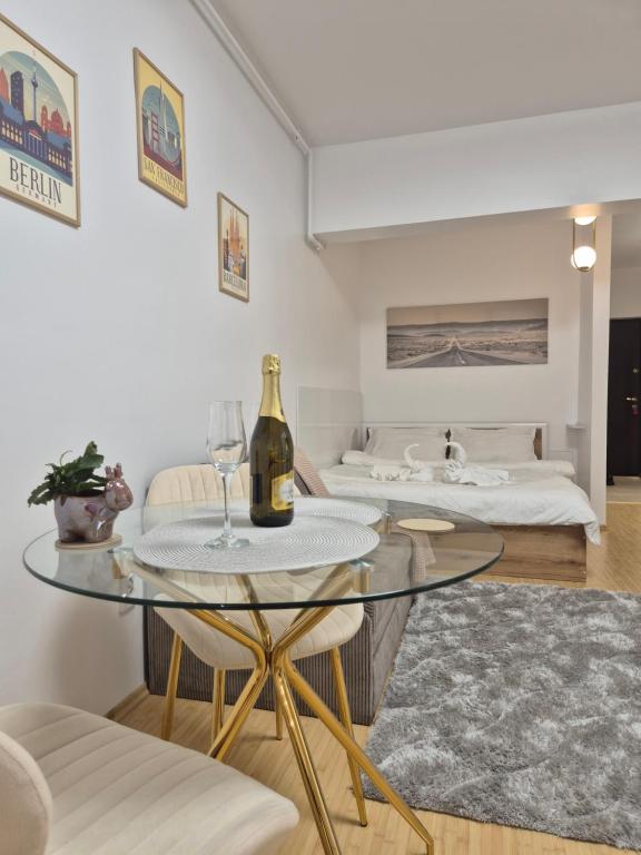a living room with a glass table and a bed at ZenCozy Studio - Free Underground Parking in Bucharest