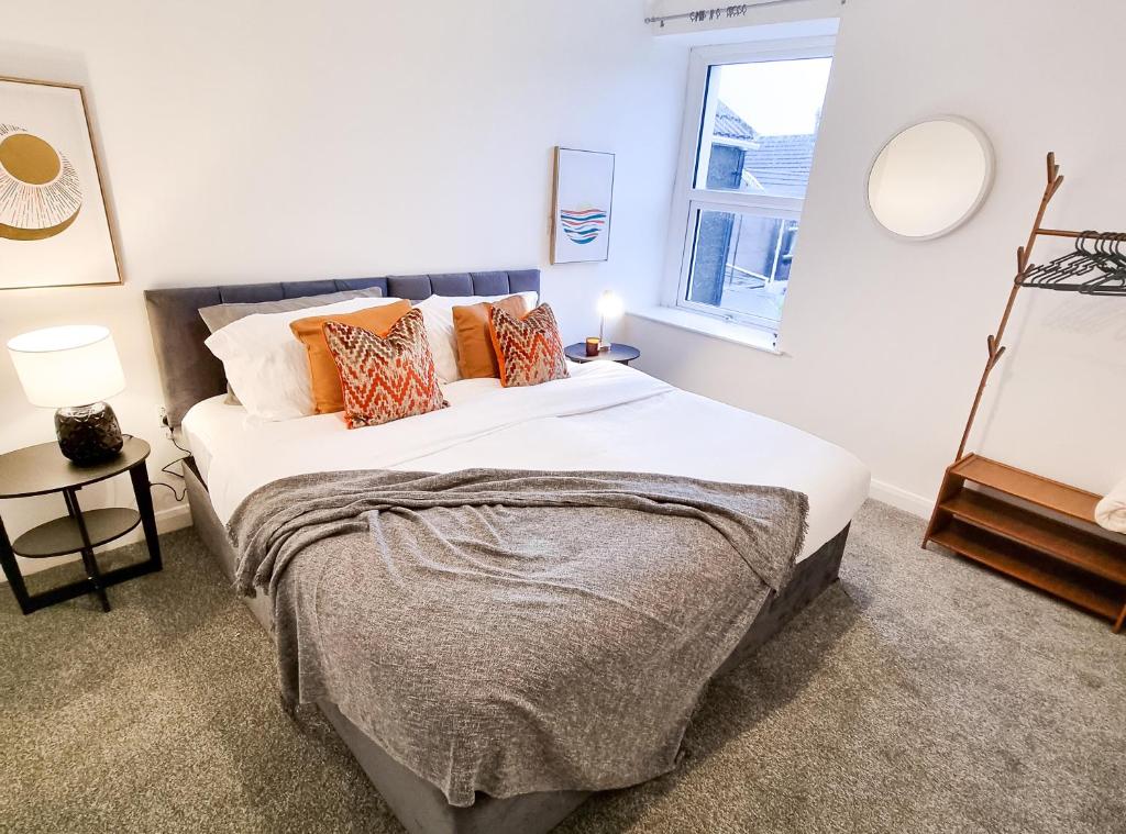 a bedroom with a large bed and a window at Urban Escape Stylish 3BR in Swansea in Swansea