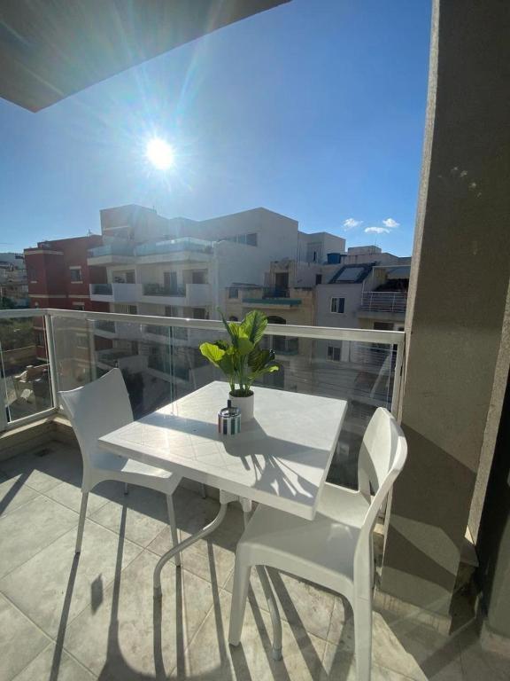 a white table and chairs on a balcony with a view at Marija Block St Julian's Apartments in Is-Swieqi