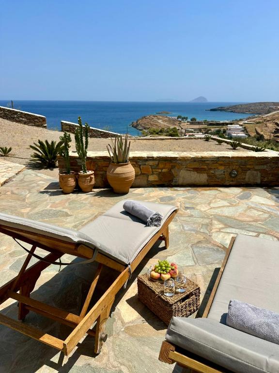 a patio with a table and chairs and the ocean at Aegean Paradise, Kythnos, Naousa in Kithnos