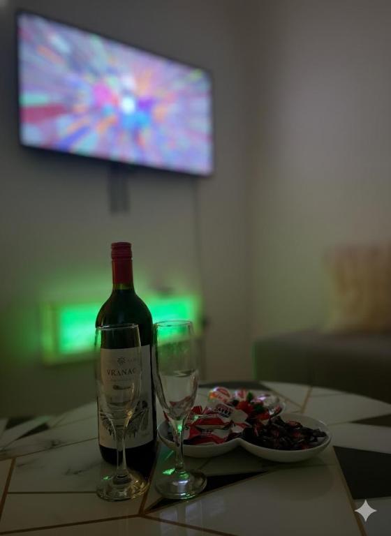 a bottle of wine and two glasses on a table at Stan na dan Lana in Vranješ