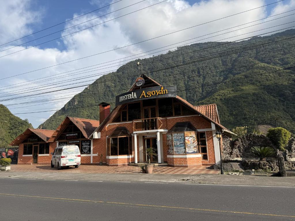 a building on the side of a road with a mountain at Hostería Agoyan Deluxe in Ulba