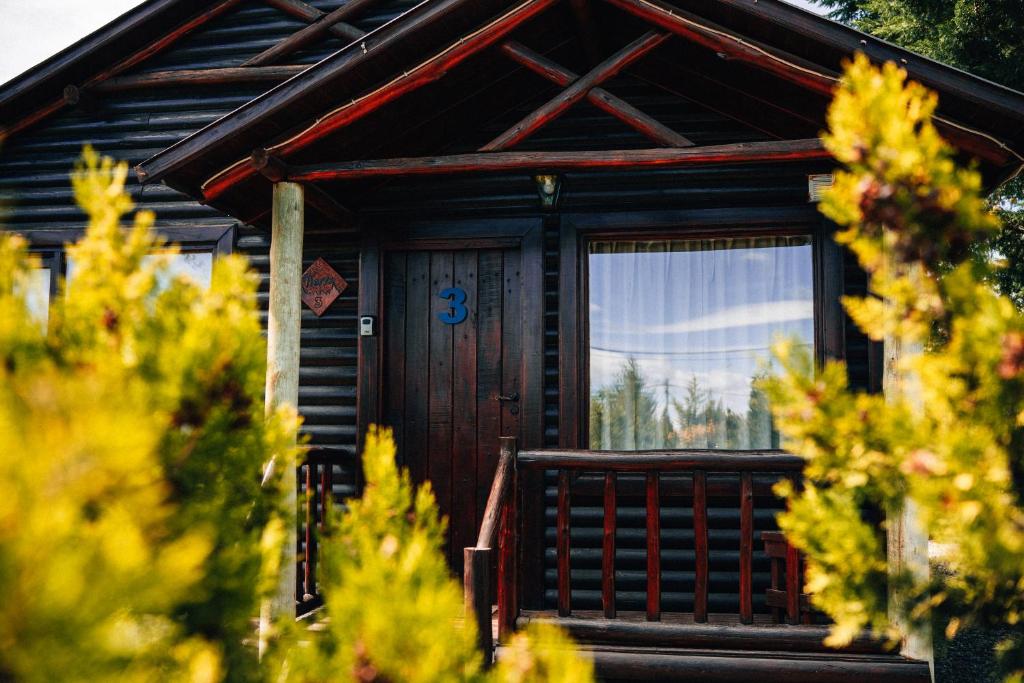 a cabin with a wooden door and a window at Paraiso Patagónico Bungalows and Aparts in El Calafate