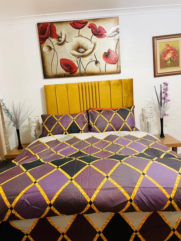 a bedroom with a purple bed and a painting on the wall at Oakley Court Room in Wallington