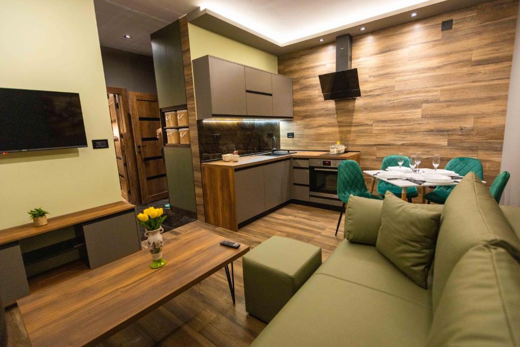 a living room with a couch and a table and a kitchen at Apartman ALPINA Bogatic in Bogatić