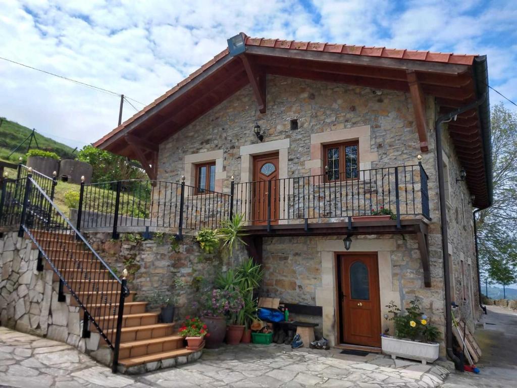 a small stone house with a staircase in front of it at La Casa del Acebal (Solorzano - Cantabria) in Solórzano