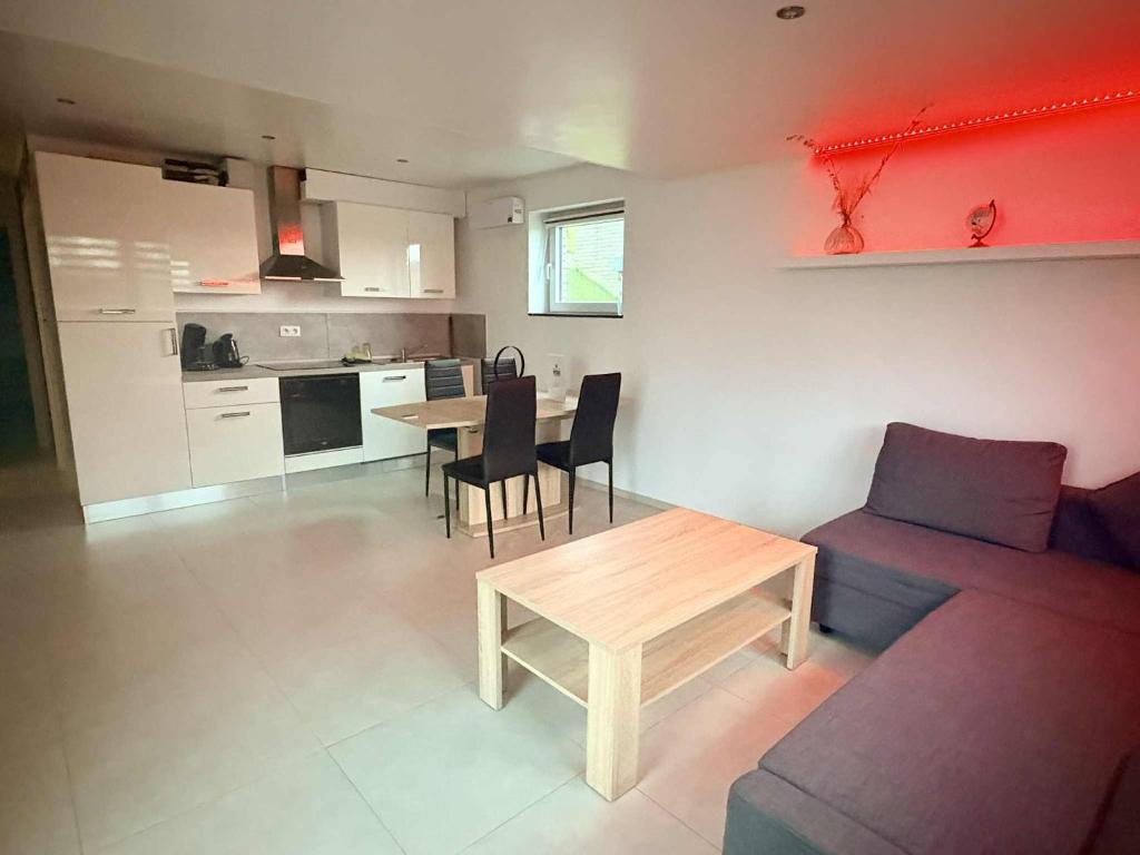 a living room with a couch and a table at Le Paradis d'Ayli in Aywaille