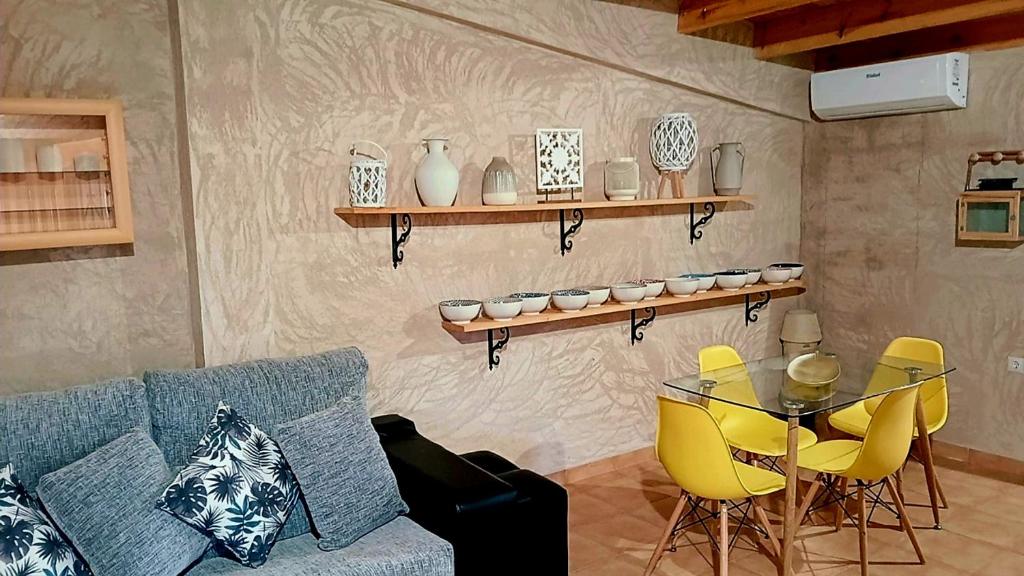 ein Wohnzimmer mit Sofa, Tisch und Stühlen in der Unterkunft Casita Bonita in Villafamés