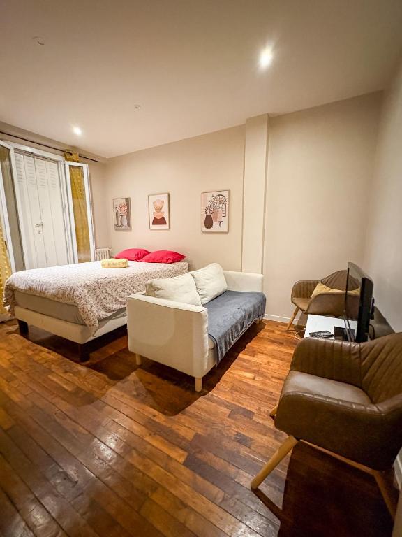 a bedroom with a bed and a couch at Centre ville - Houilles in Houilles