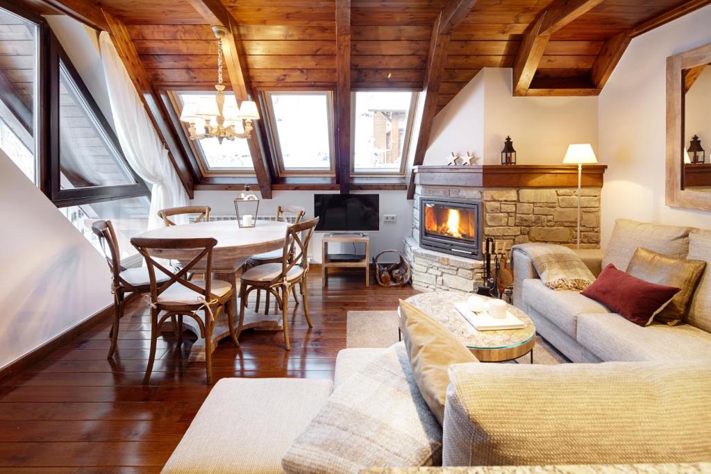 sala de estar con mesa y chimenea en Val de Ruda Luxe 24 by FeelFree Rentals, en Baqueira Beret