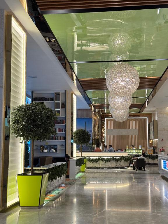 a lobby with a chandelier and potted trees in a building at XING LUN KLCC Platinum Suites in Kuala Lumpur