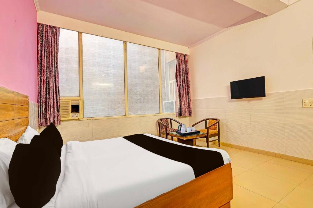 a bedroom with a bed and a window and a television at Collection O Rewari Central Railway Junction in Rewāri