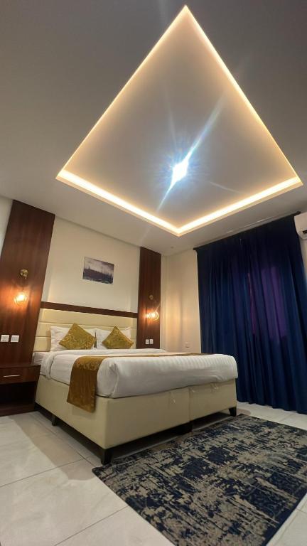 a bedroom with a large bed with a ceiling at المبيت 2 جديد in Abha