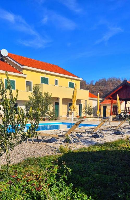 a resort with a swimming pool and a building at Villa Ruzin Dvor in Donji Vinjani