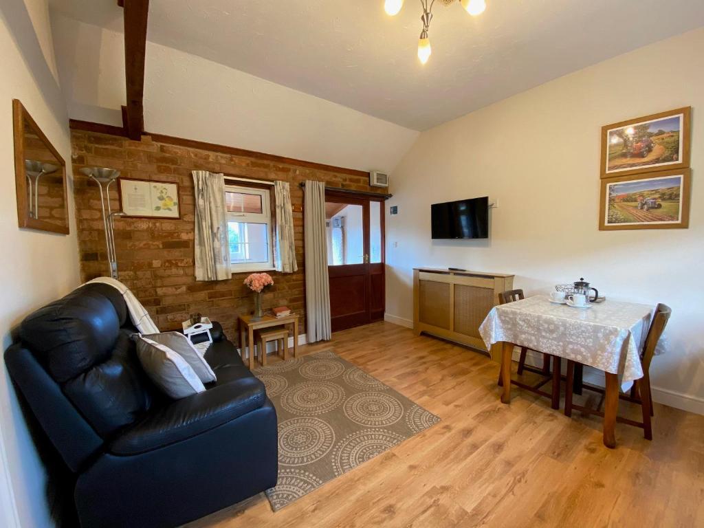 a living room with a couch and a table at Brown Snout in Ledbury