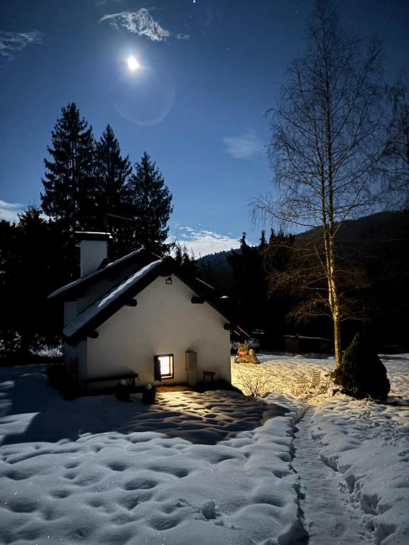 a small house in the snow at night at Casera Marisa Nevegal in Nevegal