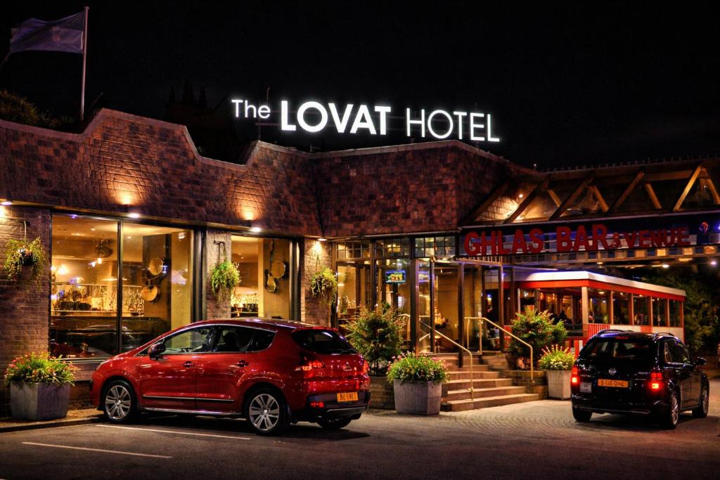 two cars parked in front of a hotel at night at Lovat Hotel in Perth