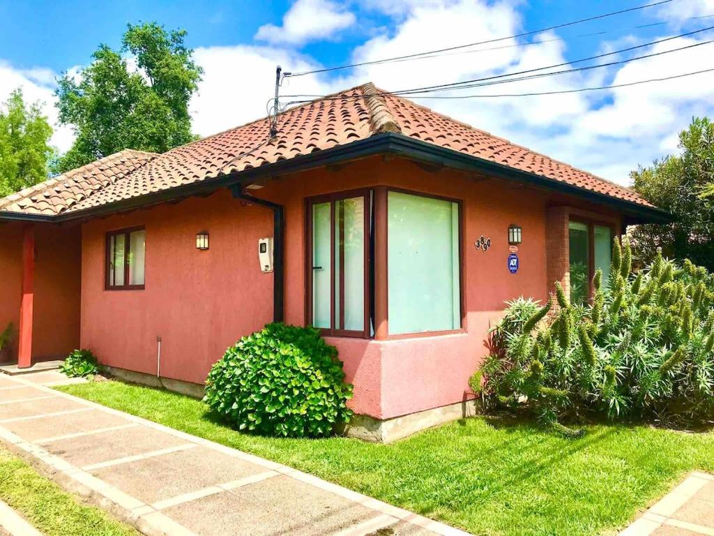 a small red house with a green yard at Casa del Parque in Talca