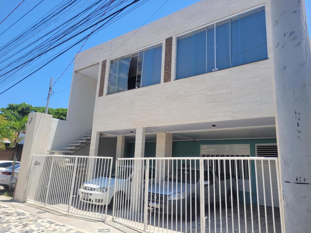 a house with a white fence in front of it at Pousada Sossego da Praia AJU in Aracaju