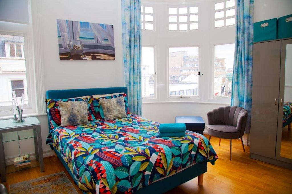 a bedroom with a bed with a colorful comforter at High Street 3BR city views near beach - Groups, Families, Contractors in Bournemouth