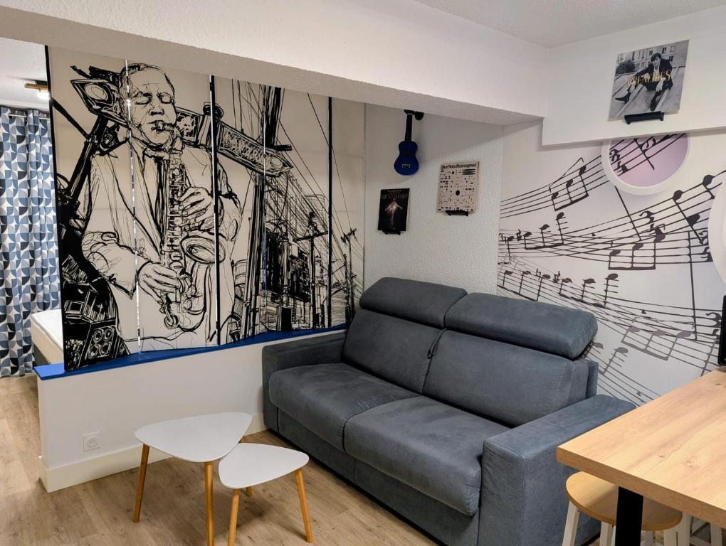 a living room with a couch and a drawing on the wall at Studio Music Blue - Bourgoin Centre in Bourgoin