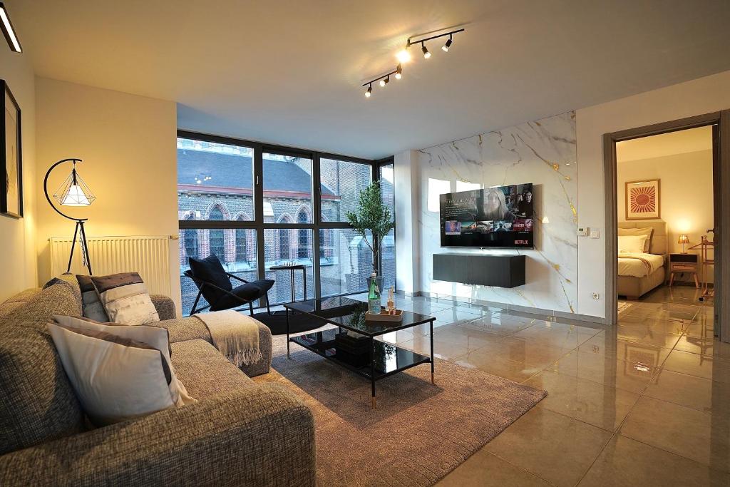 a living room with a couch and a table at Chic Loft Facing Neo-Gothic Church in Ghent
